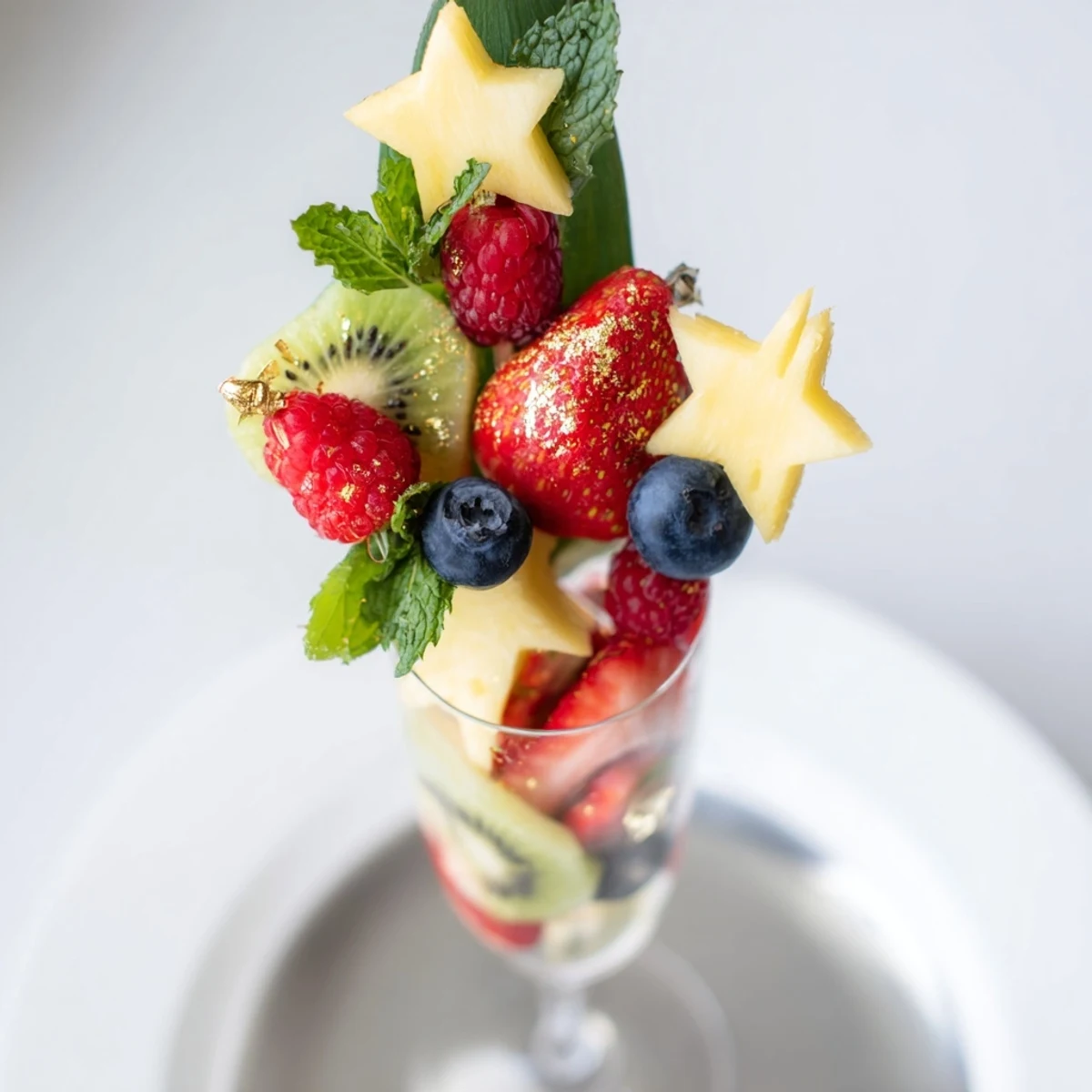 Champagne flute fruit garnishes sparkle, with strawberries, kiwi, and pineapple ready to adorn bubbly glasses.