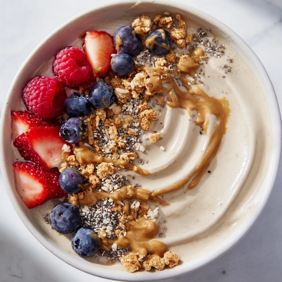 Enjoy a refreshing scoop of homemade protein ice cream bowls with granola and creamy nut butter.
