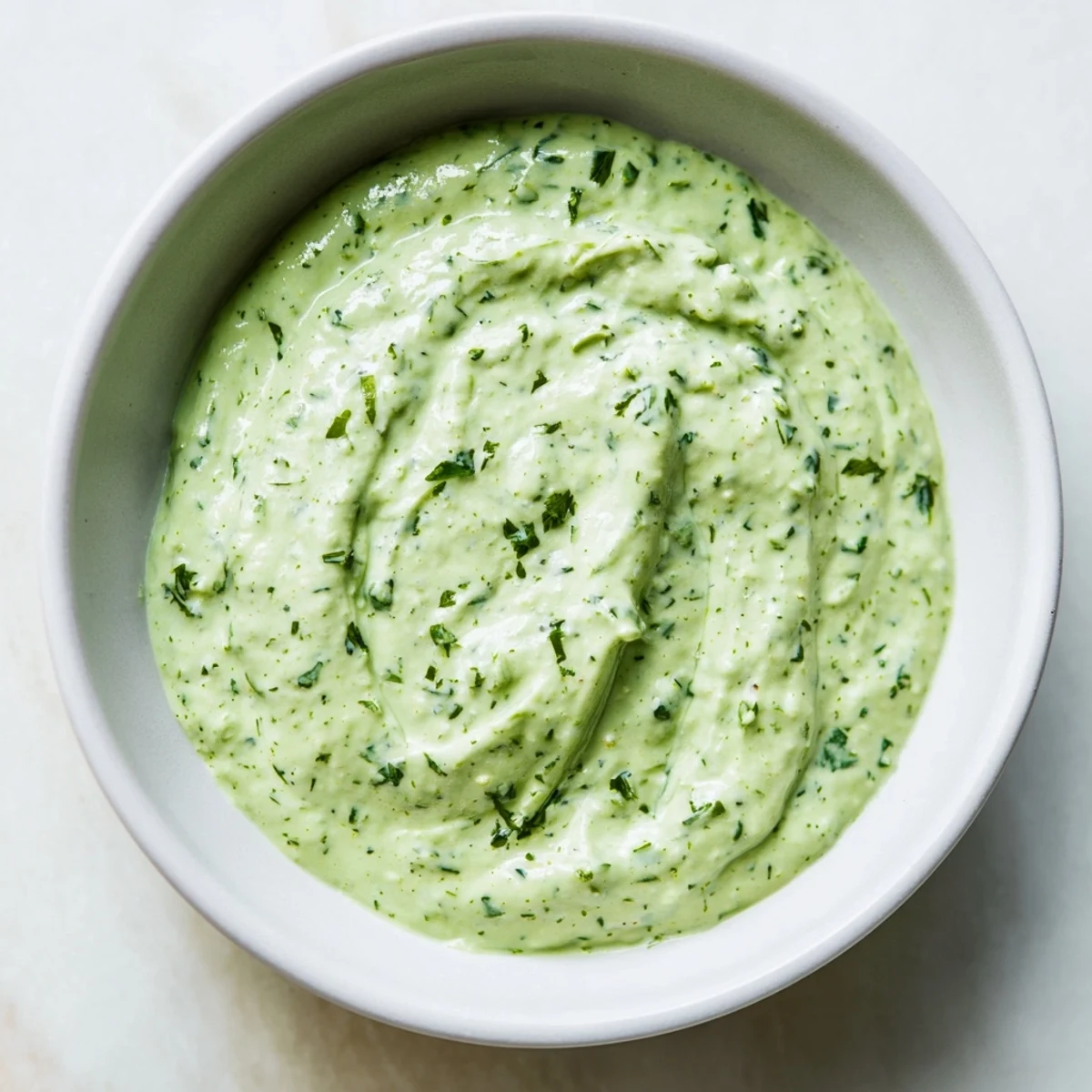 Bright, fresh ingredients for Green Goddess Salad Dip are blended into a smooth, vibrant green dip, perfect for a party platter or healthy snack.