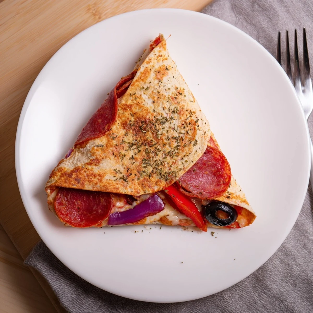 Golden, crispy Tortilla Pizza Wrap folded into a triangle, filled with melted mozzarella, pepperoni, and vibrant bell peppers.