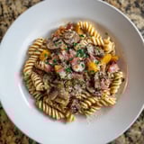 Close-up of fusilli with bacon, onions, and mushrooms, showing perfectly cooked pasta, creamy cheese, and crispy bacon.