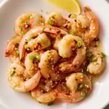 Vibrant photo of the finished Korean Garlic Butter Shrimp, garnished with scallions and sesame seeds.