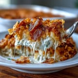 Greek yogurt funeral potatoes casserole with melted cheddar, shredded hash browns, and buttery cornflake crust.  