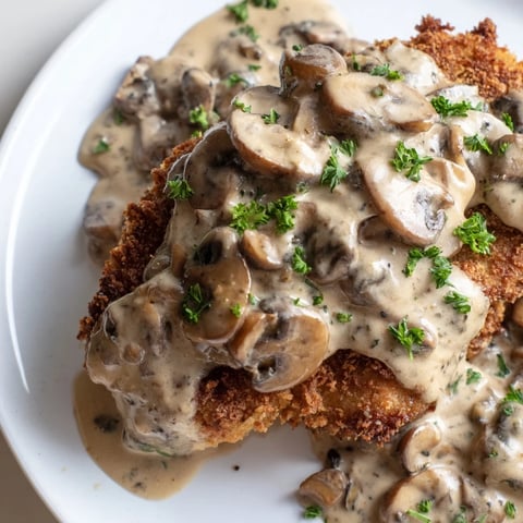 Golden-brown Jaeger Schnitzel with creamy mushroom gravy, a classic German comfort food dish.