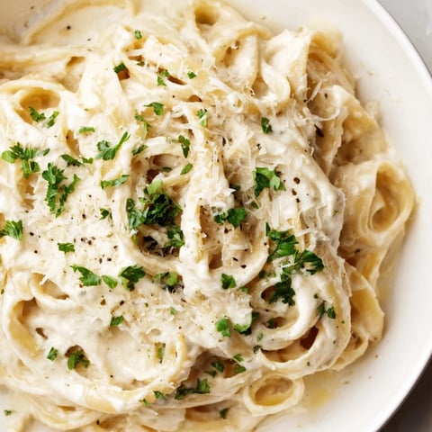 Creamy, dreamy cottage cheese Alfredo sauce over pasta, with fresh parsley garnish; Italian-American comfort food.