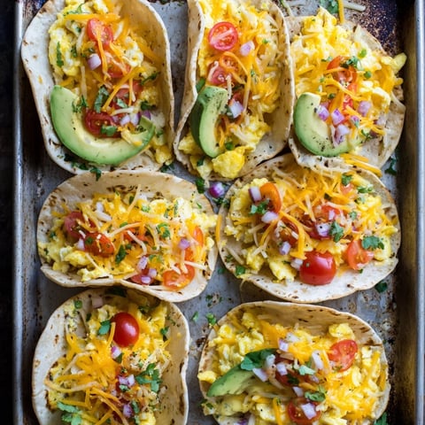 Golden-brown Sheet Pan Breakfast Tacos with fluffy eggs and melted cheddar cheese.