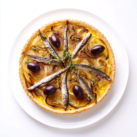 Crisp, golden-crusted Classic Onion Pissaladière Tart, topped with anchovies and olives, ready to serve this appetizer.