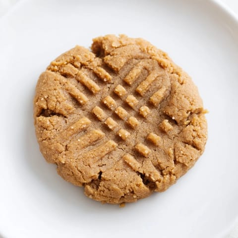 Close-up of perfectly textured flourless peanut butter cookies, ready to eat, showing the crisscross pattern.