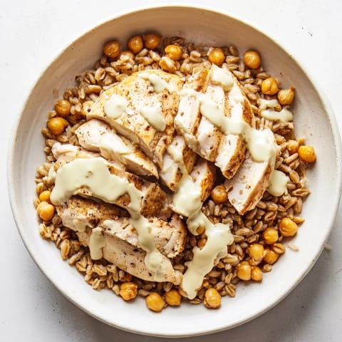 A Mediterranean-inspired power bowl with juicy chicken, crisp greens, and a creamy lemon-tahini drizzle for a nourishing weeknight meal.