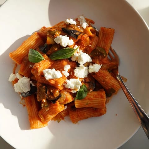 Rigatoni pasta tossed in a rich tomato sauce with golden roasted eggplant and crumbled ricotta salata cheese.