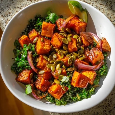 Roasted Sweet and Spicy Red Kuri Squash Bowl garnished with pepitas and fresh cilantro on a marble counter.