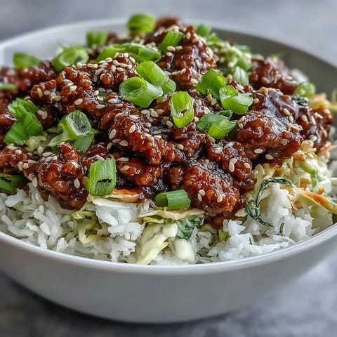 A steaming skillet of savory Egg Roll in a Bowl is topped with fresh green onions and sesame seeds.