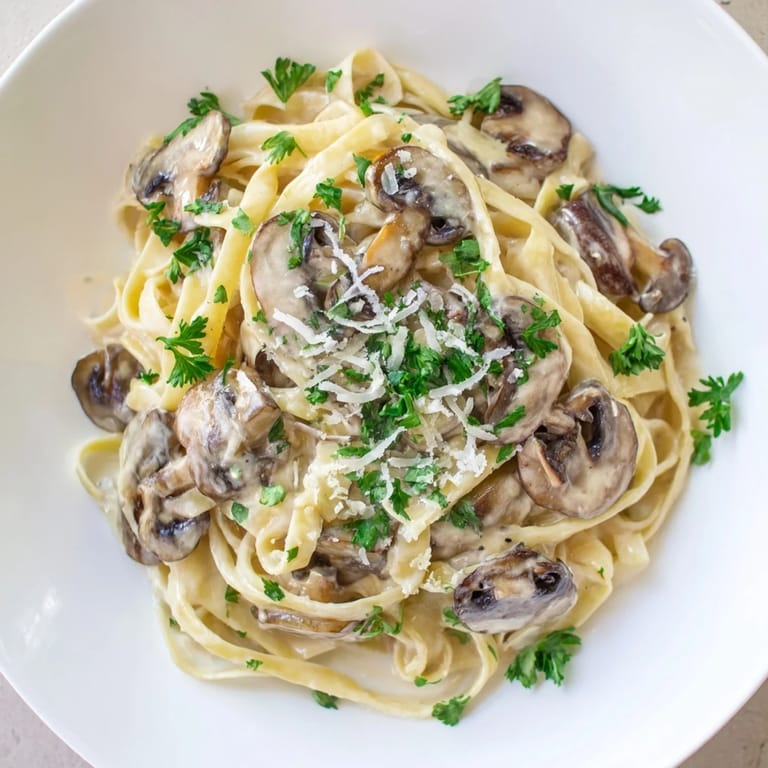 Hearty Creamy Mushroom Alfredo served warm in a skillet, with al dente pasta and extra Parmesan garnish.