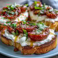 Creamy burrata and juicy peaches drizzled with honey on golden sourdough toast, perfect for a fresh spring brunch.