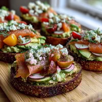 Spring Brunch Avocado Toast Board with Smoked Salmon featuring rustic sourdough, creamy avocado, and vibrant toppings arranged for easy sharing.