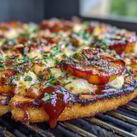 Grilled BBQ peach and Brie flatbread with caramelized onions and fresh basil, served on a wooden board.